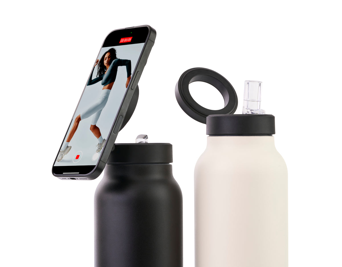 Botella South Steel de 710 ml en negro y marfil, con un teléfono sujeto al soporte magnético.
